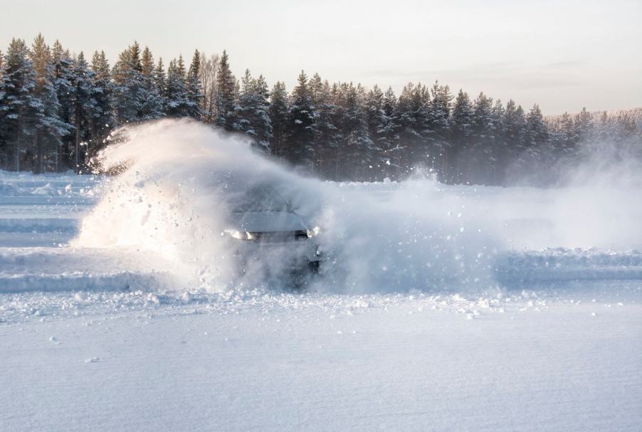 Car doing donuts and skidding across a snow-covered parking lot.