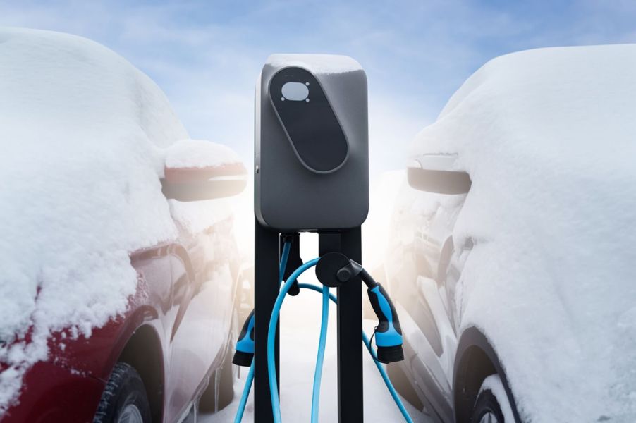 Two electric cars sit next to an outdoor range-extending charger.