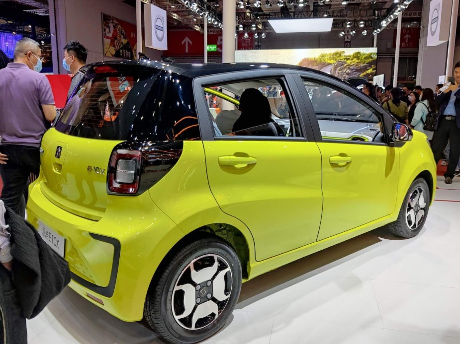 Neon green EV compact car at an auto show.