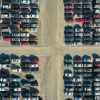 Rows of crossover SUVs and cars parked in a salvage yard.