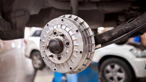 Futuristic alloy brake drum with cooling fins, attached to a car.