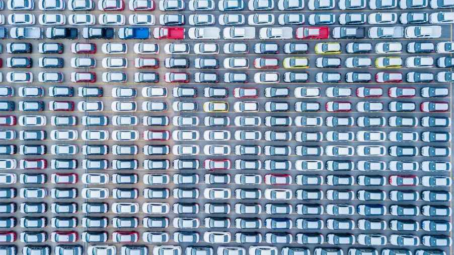 An aerial view of dozens of new cars lined up in a lot