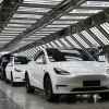 A row of white Tesla cars are shown on the factory floor in Shanghai