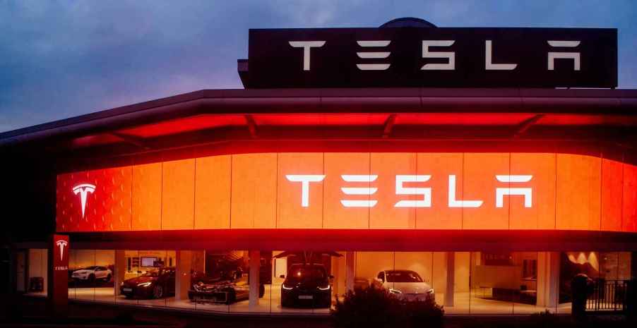 A Tesla showroom with red and white glowing lights at night