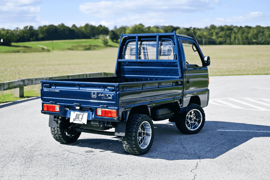 A blue 1993 Honda Acty kei pickup truck shown parked at right rear angle