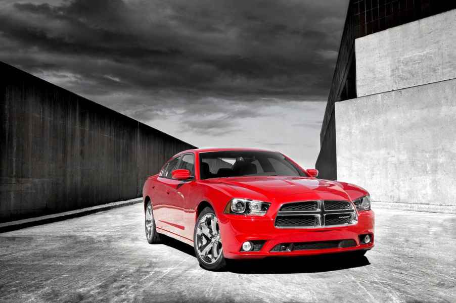 A red 2012 Dodge Charger is parked in right front angle view black and white background