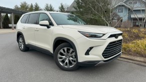 The 2024 Toyota Grand Highlander Hybrid parked near trees