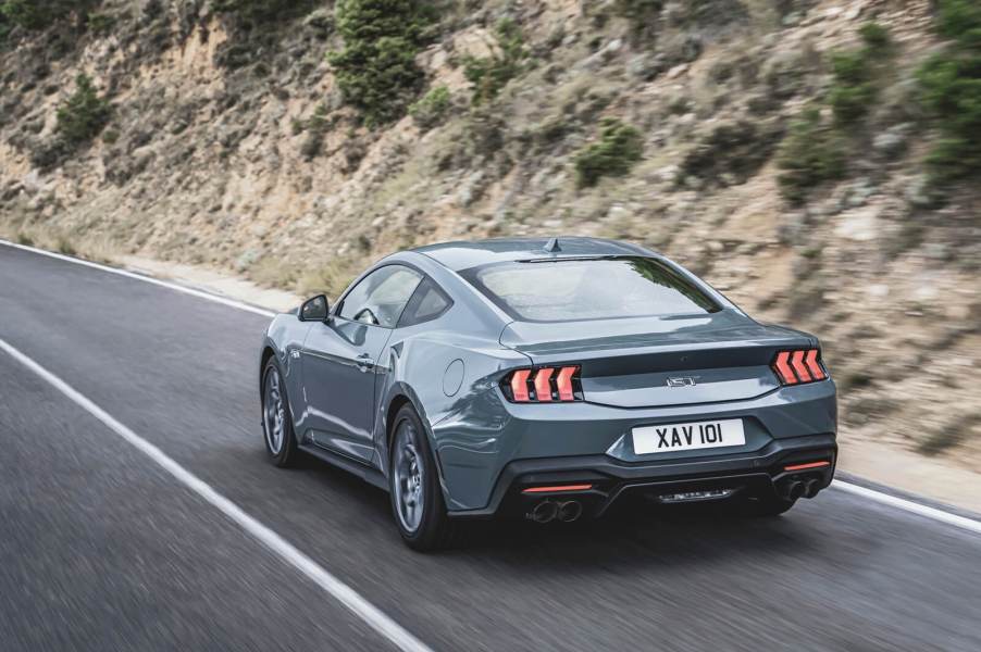 A 2024 Ford Mustang GT, the pricier alternative to the EcoBoost, drives down a mountain road.