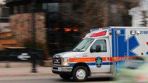 White ambulance racing down a city street.