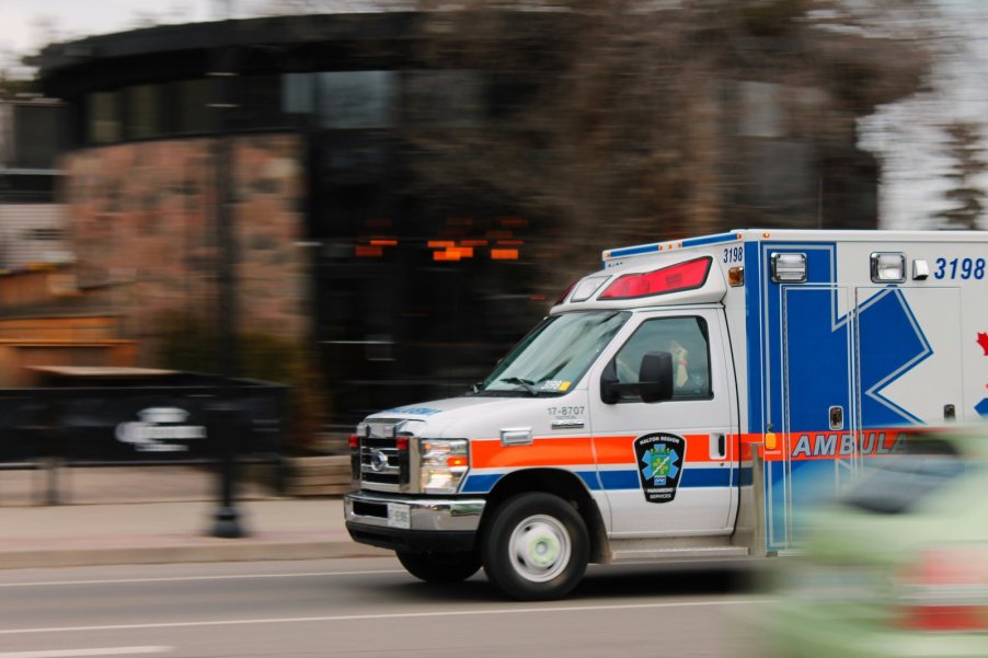 White ambulance racing down a city street.