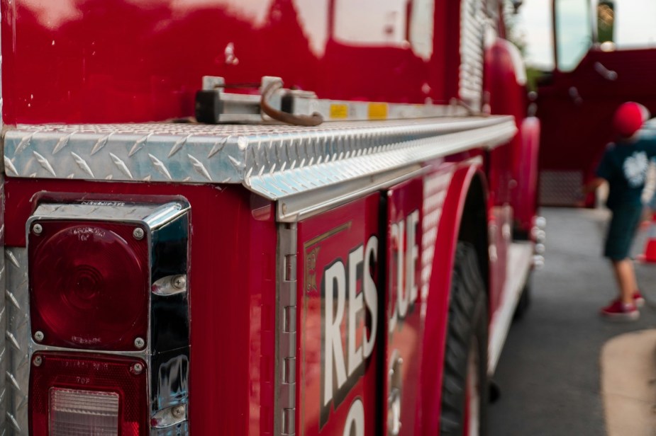 The corner of a red fire truck with "Rescue" painted on the side.