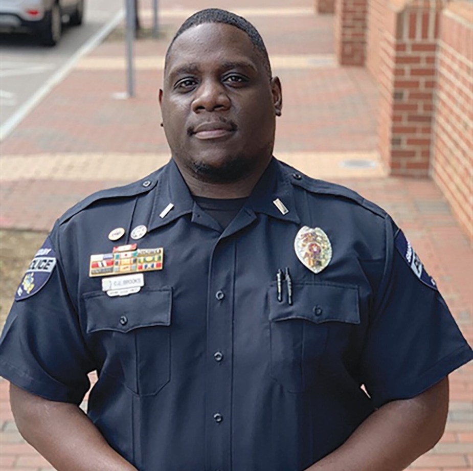 Police officer in uniform stands at attention.