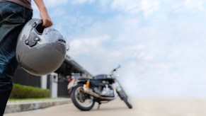 A rider approaches a motorcycle to go for a ride.