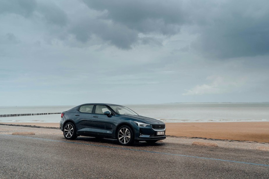 Black Polestar 2 electric car (financed by Volvo) parked on a beach