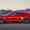 Red Porsche station wagon parked in front of a mountain sunset