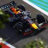 A drone captures an image of Max Verstappen driving a Red Bull F1 car.