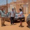 James May, Jeremy Clarkson, and Richard Hammond pose next to a Maserati GranCabrio and an Aston Martin DB9 in Mauritania.