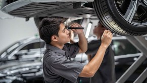 A man inspects the tire on a car