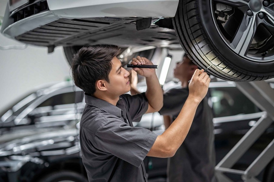 A man inspects the tire on a car