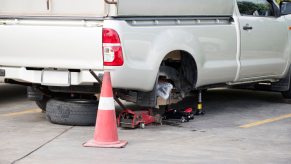 A utility pickup truck on a jack for maintenance