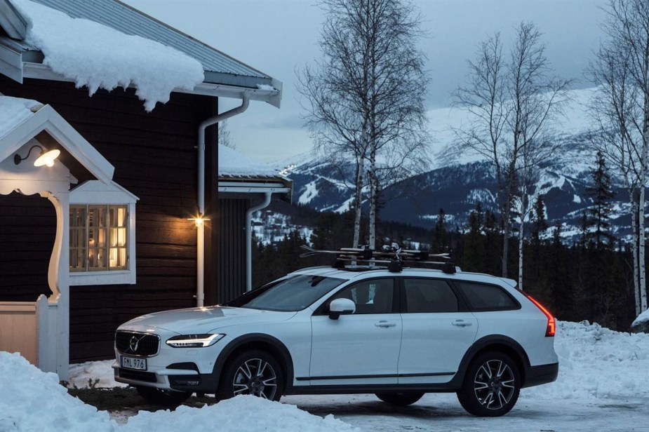 White Volvo station wagon at a ski area cabin.