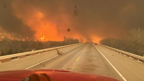 First-person view from inside a Texan fire truck driving on a paved road towards a wildfire