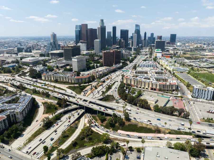 An aerial view of 'The Stack,' LA's Four-Level Freeway Interchange with Downtown LA in the background