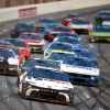 NASCAR cars in a large group on the track during the 2024 Cup Series Ambetter Health 400