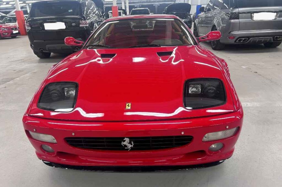 A red mid-90s Ferrari F512M owned by former F1 driver Gerhard Berger is shown in direct front view