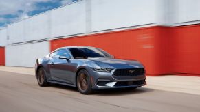 A new 2024 Ford Mustang EcoBoost S650 drives through a harbor.