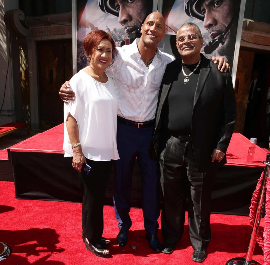 Dwayne Johnson standing between his parent.s