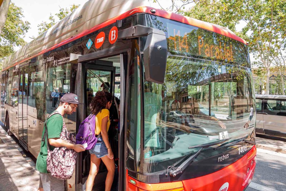 Passengers board a red bus in Barcelona