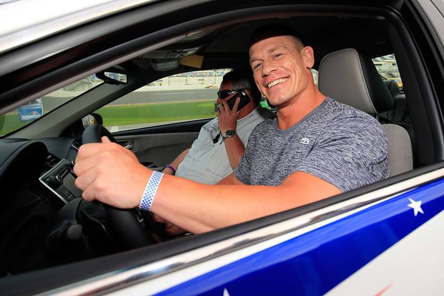 John Cena, the voice of Honda car commercials, sits in a race car.