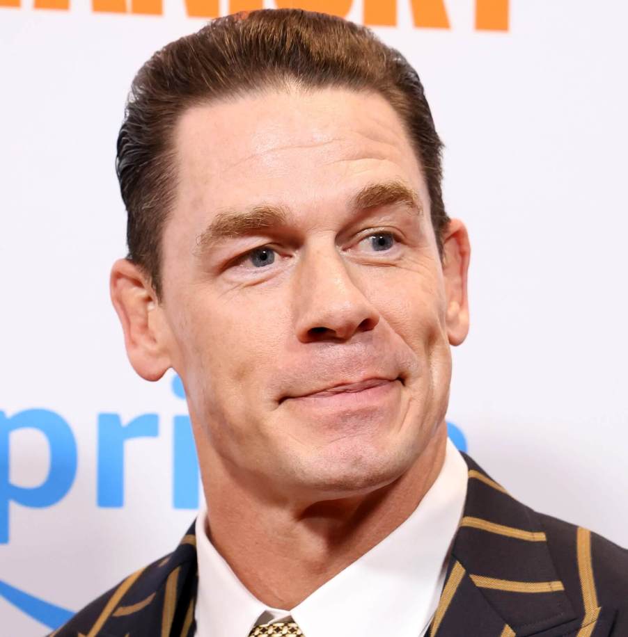 A smirking John Cena takes a picture at an event.