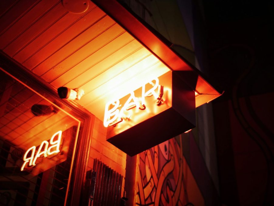 The neon "bar" sign by a bar's mirror.