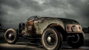 Ratty hot rod car in front of a gray sky