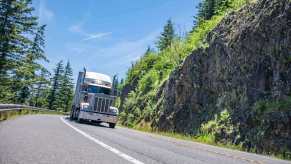 A semi truck drives around a corner.