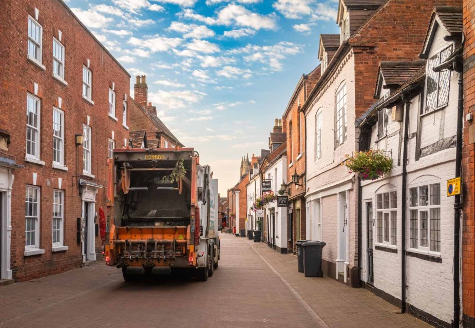 Garbage truck driving past apartment buildings in the U.K.