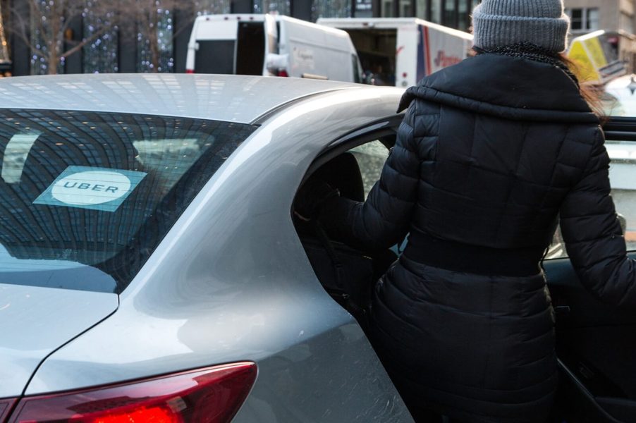 A Gen Z adult hops into a rideshare like an Uber.