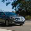 A dark grey 2012 Hyundai Sonata driving in right front angle view