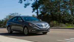 A dark grey 2012 Hyundai Sonata driving in right front angle view