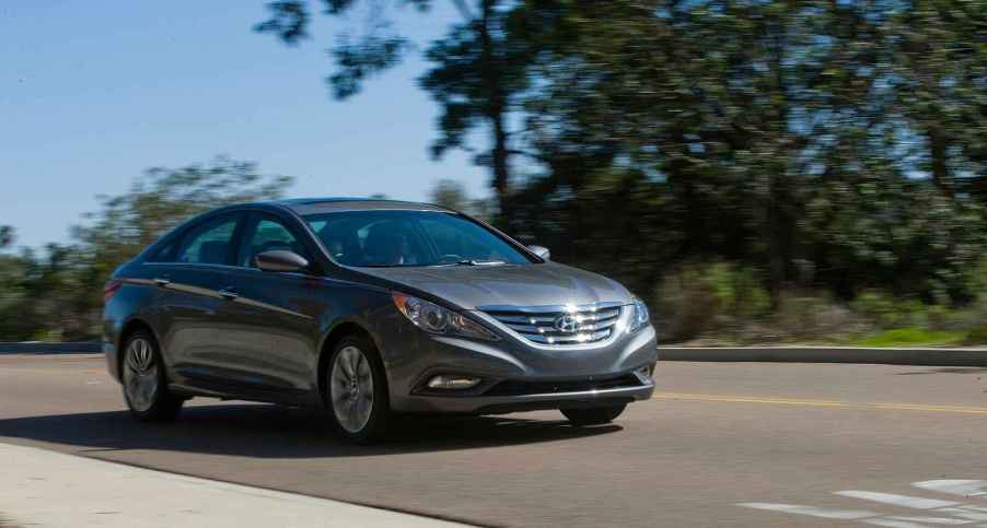 A dark grey 2012 Hyundai Sonata driving in right front angle view