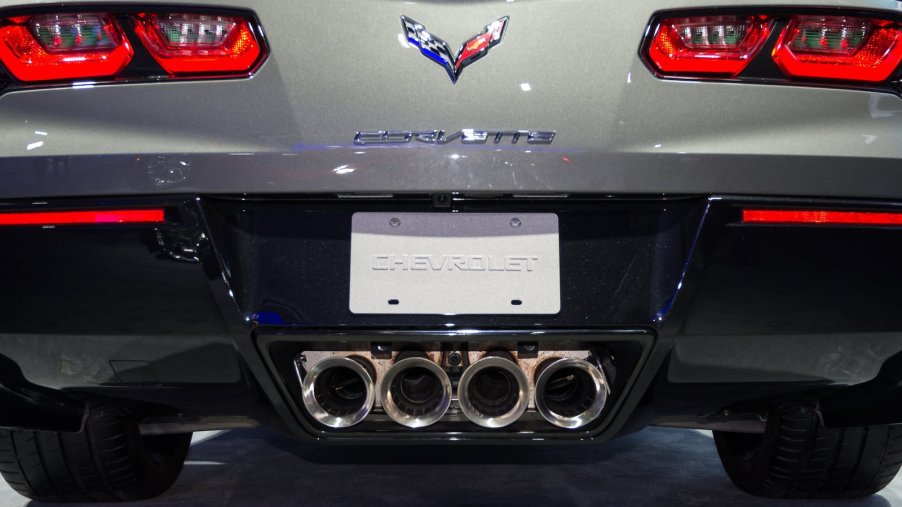 The four exhaust tailpipes in the rear bumper of a Chevrolet Corvette sports car.