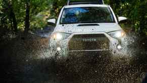 A white 2020 Toyota 4Runner TRD Pro in direct front view driving through large muddy puddle