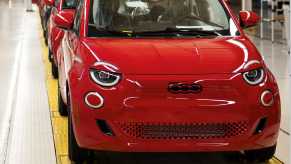 Row of red Fiat 500e EVs on a factory floor