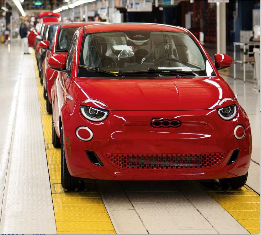 Row of red Fiat 500e EVs on a factory floor