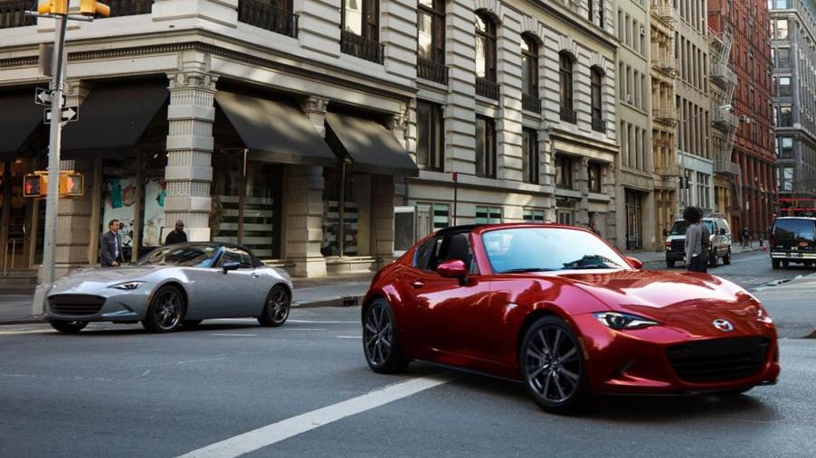 White and Red 2024 Mazda MX-5 Miatas driving In a City