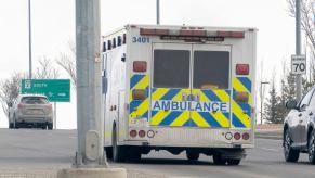 An ambulance driver drives the rig away from a photographer.