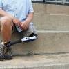 An amputee with one leg sits on steps.