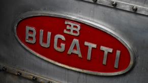 The red Bugatti logo stamped on the side of a metal engine block.